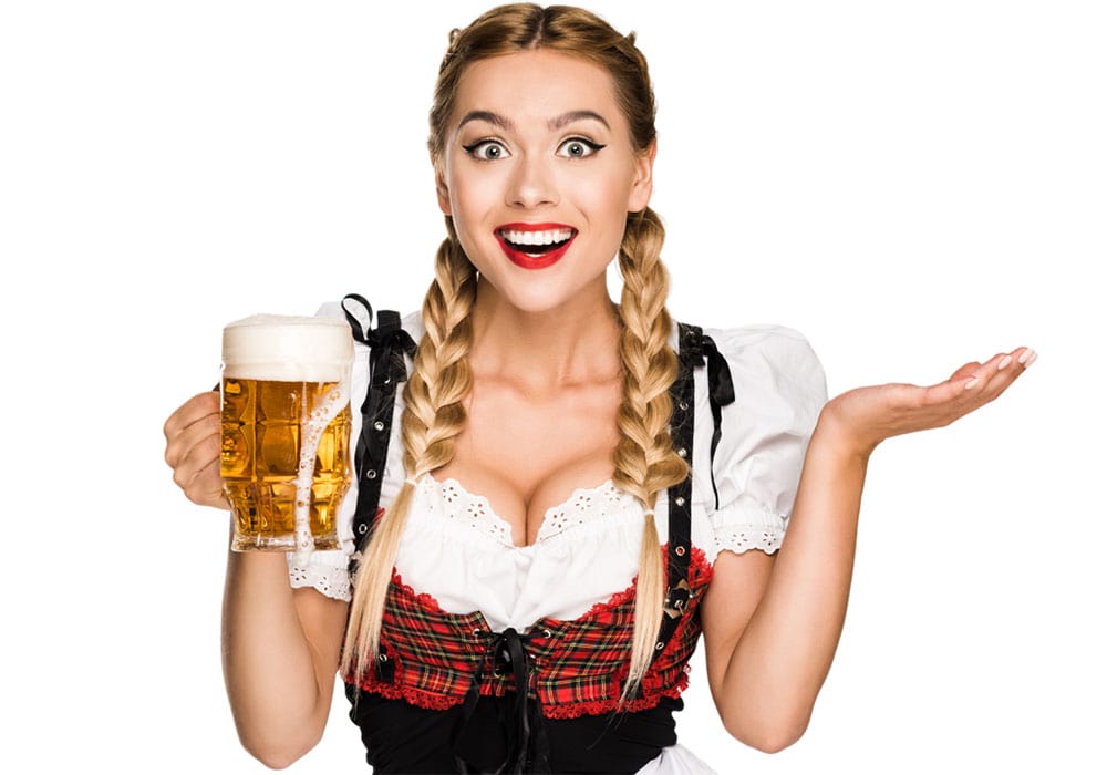 Cheerful blonde beer hostesses wearing a traditional Bavarian outfit holding a beer.