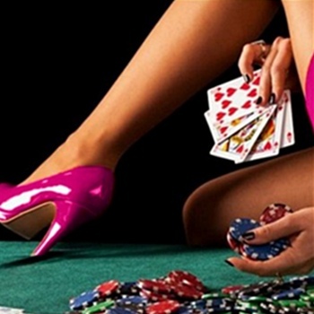 Woman in pink heels holding playing cards and poker chips at a green table with scattered chips.